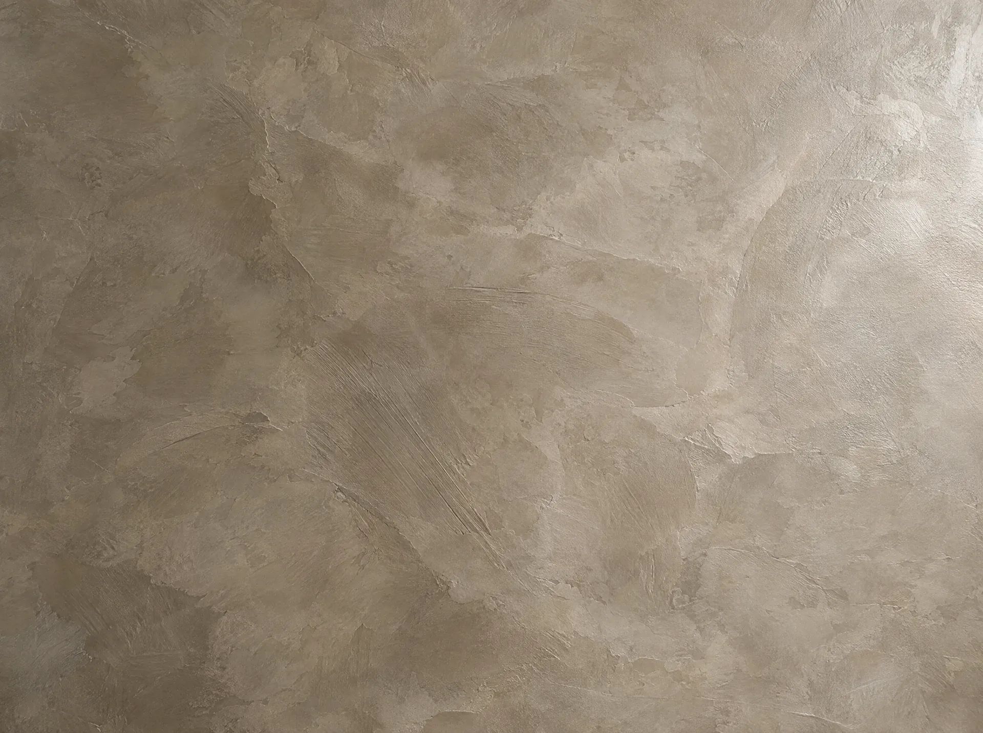 Detail stěny z mikrocementu v odstínu taupe: stopy hladítka a saténová, vícetónová textura